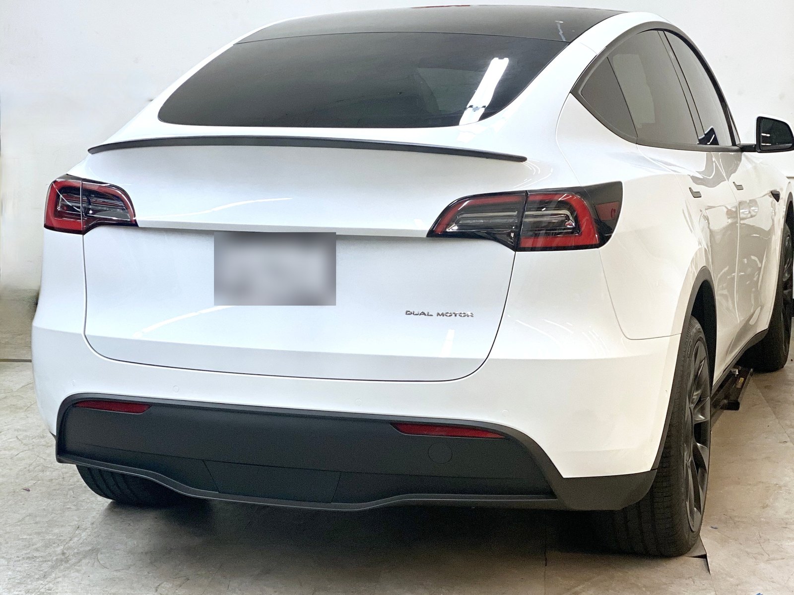 Performance-spoiler i matt kolfiber monterad på Tesla Model Y bakifrån